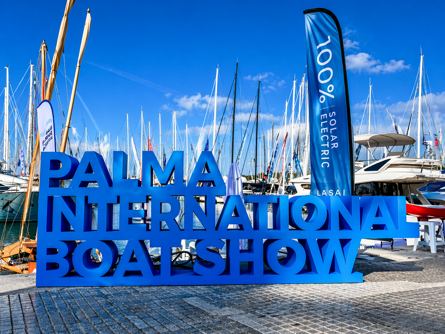 Palma International Boat Show 2026 – Privatflug ab der Schweiz: Blick auf den Eingang der Bootsmesse im Hafen von Palma de Mallorca mit blauem Messeschild und Masten im Hintergrund.
