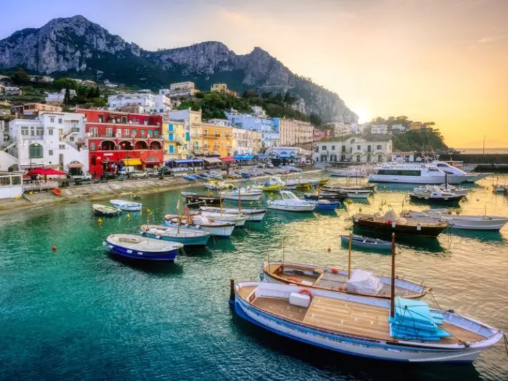 Old town alley in Capri with pastel-colored facades, boutiques and terrace cafes in a Mediterranean island atmosphere