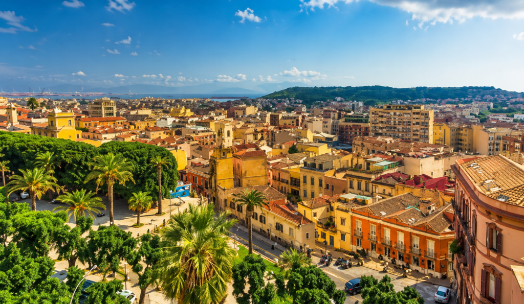 Panoramic views over Cagliari in Sardinia with its Mediterranean old town, palm trees, sea views and sunny coastal landscape – private flight from Switzerland with Swiss Elite Flight.